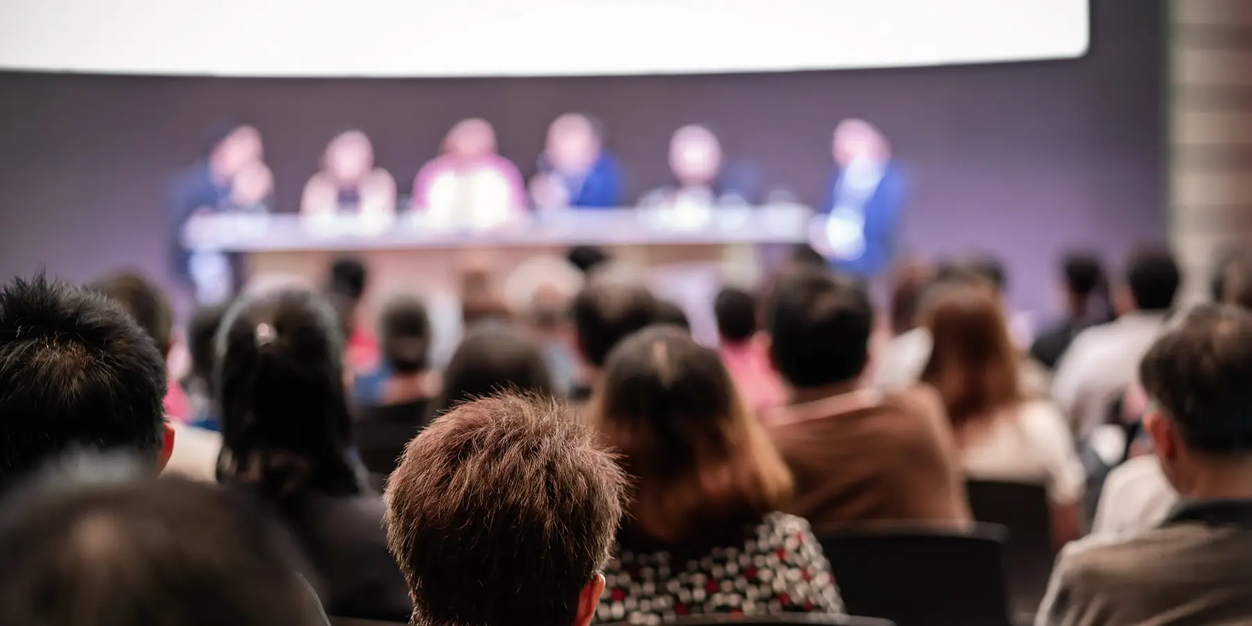 A blurry photo of a panel in a busy conference room