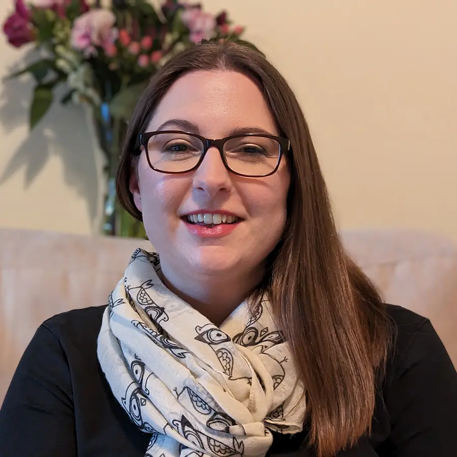 A white woman with long brown hair and glasses